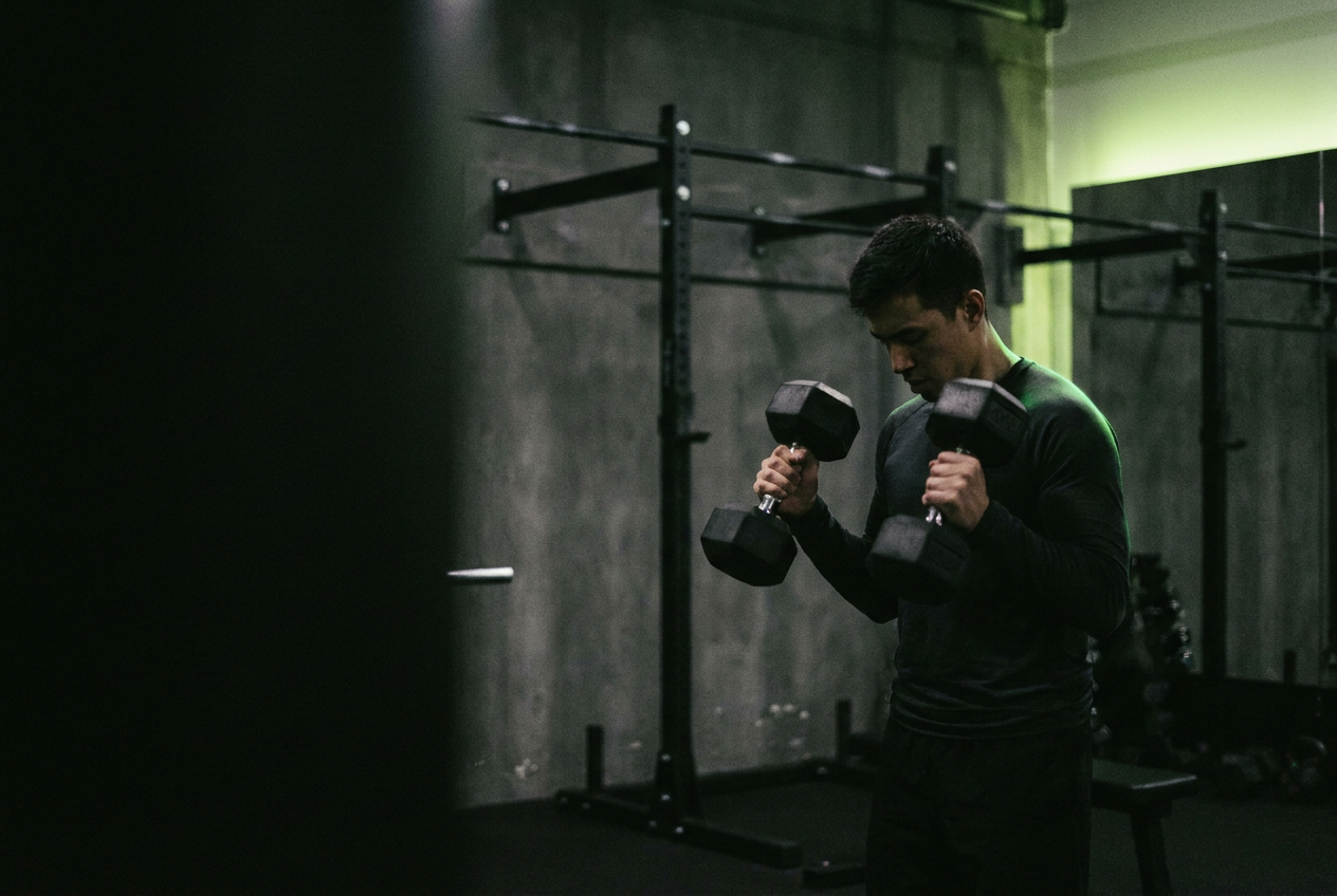 Atleta che si allena con i manubri in palestra